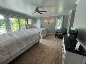 A bedroom with two beds, a ceiling fan, and a TV on a dresser.