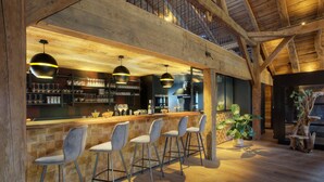 Zona de bar con vigas de madera, techo alto y ambiente rústico.
