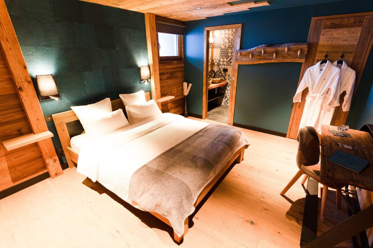A bedroom with a wooden bed, a desk, and a chair.