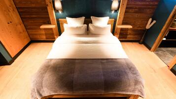 A wooden bed with a headboard, two bedside tables, and a window.