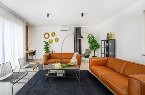 Uma sala de estar moderna com um sofá, mesa de centro e cadeiras.