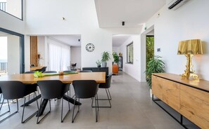 Ein moderner Essbereich mit Holztisch, schwarzen Stühlen und minimalistischem Design.