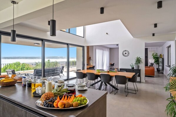 Uma cozinha moderna com balcão de refeições, grandes janelas e área de jantar com vista.