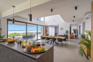 Uma cozinha moderna com bancada para refeições rápidas, janelas amplas e área de jantar com vista.