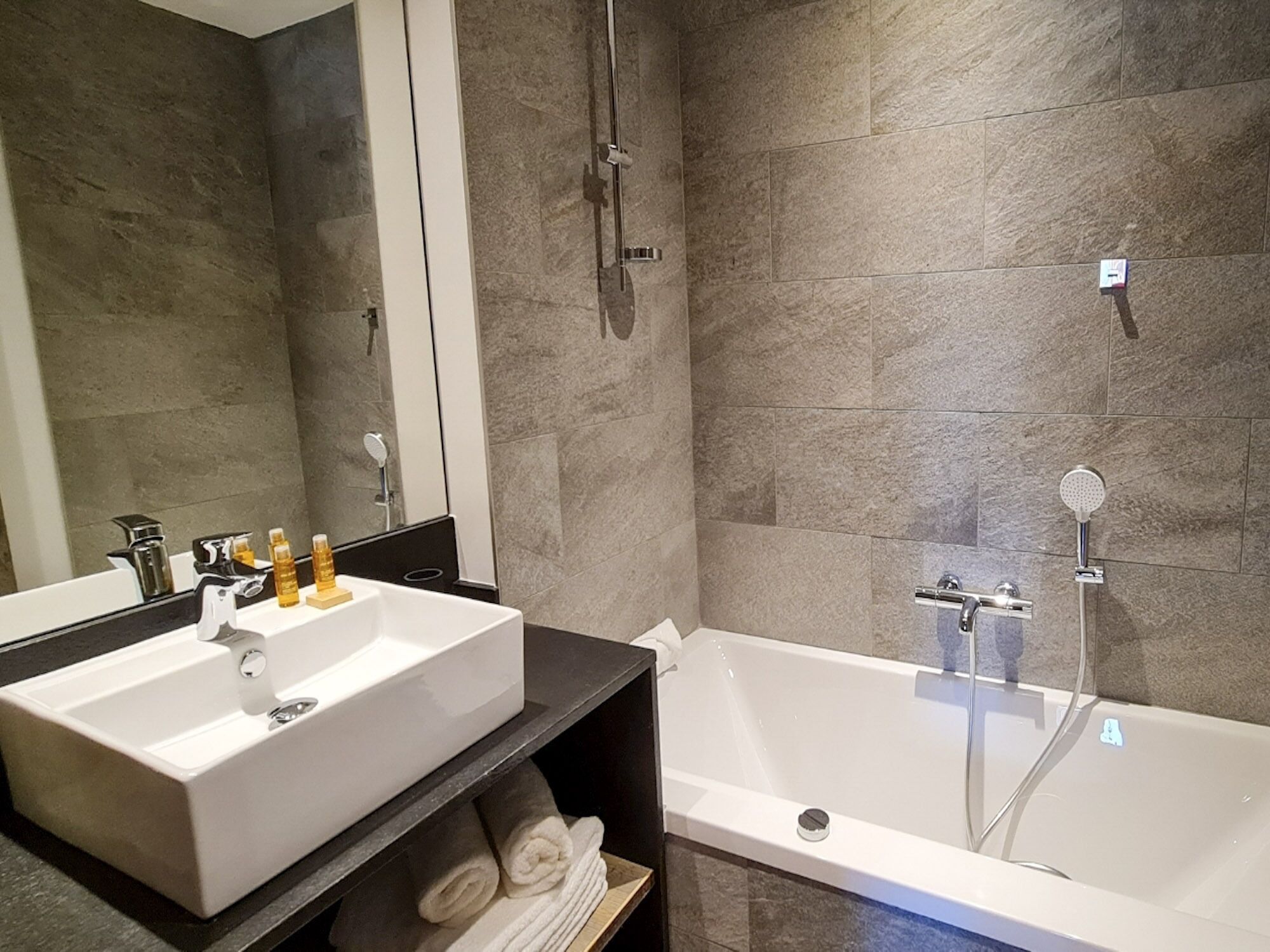 Ein Badezimmer mit einem Doppelwaschbecken, einer Badewanne und einem Spiegel.