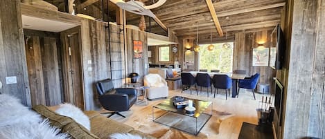 A rustic interior with a sofa, a dining area, and a kitchen.