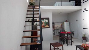 A compact living space with a loft bedroom, a dining area, and a staircase. - Loft " El Mestizo" (Celestún)