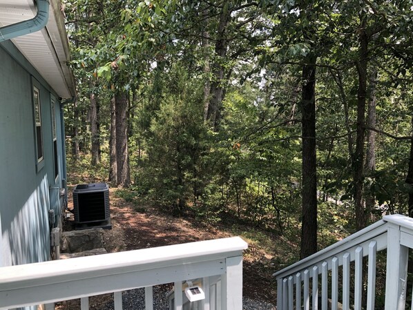 A house with a porch overlooking a forested area.