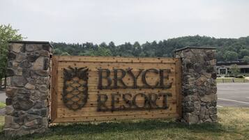Un letrero de madera con la leyenda "Bryce Resort", flanqueado por pilares de piedra.