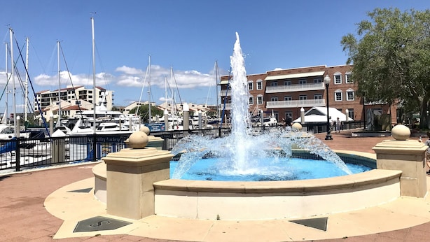A marina with boats, a fountain, and buildings in the background. - Palafox Loft 122, sleeps 2 (Pensacola)