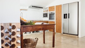 Une cuisine moderne avec des meubles en bois, un réfrigérateur en acier inoxydable et un four encastré.