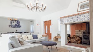 Un salon moderne avec un canapé, un pouf et une cheminée.