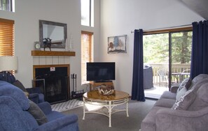 A living room with a fireplace, a television, and a view of the outdoors. - Quality Resort Villa - PINETOP (Pinetop)