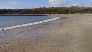 Una playa con arena y un mar tranquilo.