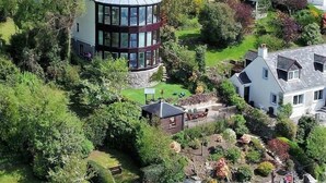 Luftaufnahme eines Wohngebiets mit Häusern, einem runden Turm und einem Garten.