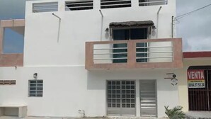 A two-story building with a balcony, a door, and a window. - Apartment Trankilo 1 (Progreso)