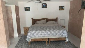 A bedroom with a bed, a ceiling fan, a nightstand, and a wall-mounted radiator. - Apartment Trankilo 1 (Progreso)