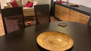 A dining area with a round table, chairs, a sofa, and a TV. - Casa Miky (Palermo)
