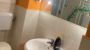 A bathroom with a white sink, a toilet, and a shower. - Casa Miky (Palermo)