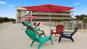 Eine Dachterrasse mit Sitzgelegenheiten im Freien und einem Pool.