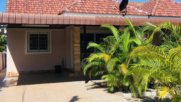 A house with a tiled roof, a satellite dish, and a small window. - Thai-scout Home (pran buri)