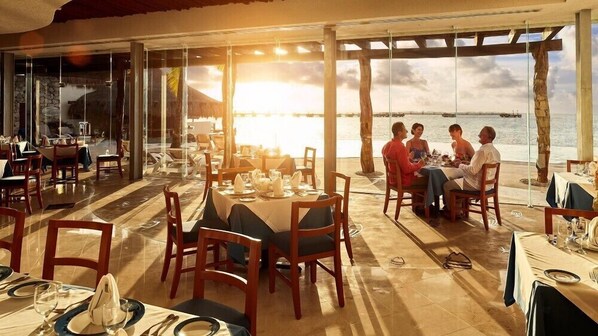 A restaurant with tables set for dining, overlooking a body of water. - Cozumel Tranquil Studio Pool & Hot Tub for Getaway (San Miguel de Cozumel)