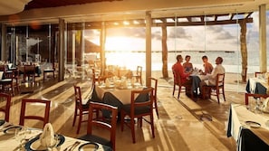 Ein Restaurant mit gedeckten Tischen und Blick auf ein Gewässer.