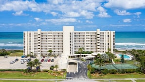 Ein mehrstöckiges Hotel mit einer zentralen Atriumlichtkuppel, Parkplatz und Schwimmbereich.
