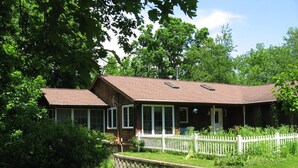 A wooden house with a white picket fence, surrounded by lush greenery. - 3 Bedroom House in Rural Setting but close to Iowa City/Solon (Solon)
