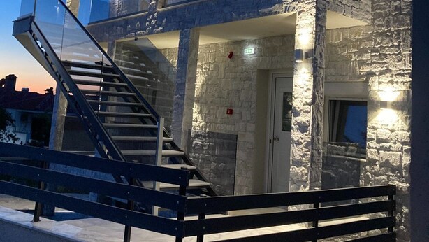 A two-story building with a stone facade, a balcony, and a staircase leading to the upper floor. - Beautiful AqvaVilla in Poreč (Porec)