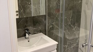 A modern bathroom with a white vanity, a large mirror, and a glass shower enclosure. - Beautiful AqvaVilla in Poreč (Porec)