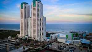 Un grand hôtel à plusieurs étages, doté d’un parking et offrant une vue sur l’océan.