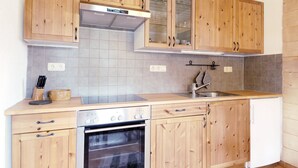 A kitchen with wooden cabinets, a stainless steel range hood, a built-in oven, and a sink. - Mountain cabin Ull Oviksfjällen, 4 people (Svenstavik)