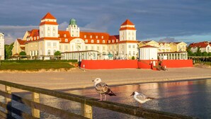 A waterfront building with a red facade and multiple towers. - Exclusive vacation apartment, Residence Margarete, close to the beach, underground parking, sauna (Binz)