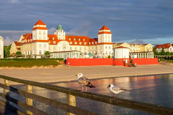 A waterfront building with a red facade and multiple towers.