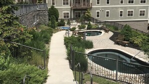 A multi-story residential building with balconies, a swimming pool, and a landscaped garden area. - Luxury Ski-in/Ski-out 2 BR, Soaring Eagle 207 (Snowshoe)