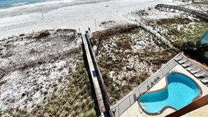Uitzicht op een strand met een zwembad en een houten vlonder.