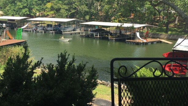 A lakeside view with docks, covered seating areas, and a playground. - 3 bedroom waterfront home Large dock and great swim area 4 KAYAKS + PADDLEBOAT (Sunrise Beach)