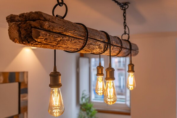 A rustic chandelier with exposed bulbs and a wooden base.
