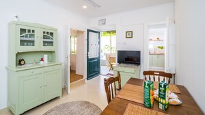 A compact living space with a dining area, kitchenette, and a television. - Apartment Marija 5 mins away from Old Town (Dubrovnik)