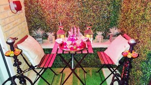 A dining area with a table set for four, surrounded by chairs, and two hookahs. - LONDON apartment with PRIVATE HOT TUB, SAUNA & GYM! (Rainham)