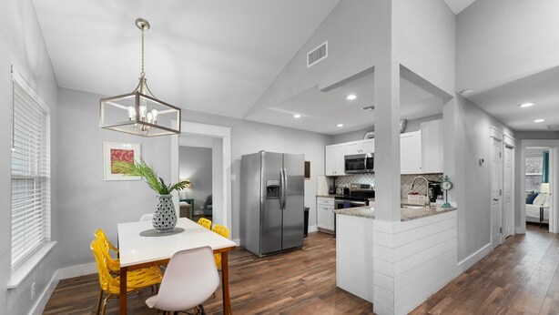 A modern kitchen with white cabinetry, a stainless steel refrigerator, and a microwave. - 4BDR+Pets OK+Huge Yard+FirePit+3mintoBeach (Rockport)