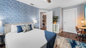 A bedroom with a bed, a ceiling fan, a nightstand, a lamp, a door, and a small table with chairs. - 4BDR+Pets OK+Huge Yard+FirePit+3mintoBeach (Rockport)
