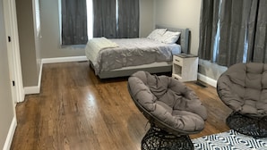 A bedroom with a bed, two bedside tables, a ceiling fan, and two armchairs. - Beautiful River front property (Celina)