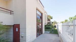 A building with a red door, a glass entrance, and a white fence. - L'Hyppocampe by Interhome (Port Camargue)