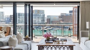 A modern living room with a city view, a sofa set, a coffee table, and a floor lamp.