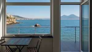Un balcon avec vue sur la mer, une table et une chaise.