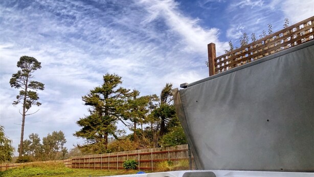 A hot tub outdoors with a wooden fence and trees in the background. - Sea La Vie - At the entrance to MacKerricher State Park and is in walking distance (Fort Bragg)