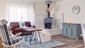 A cozy living room with a fireplace, a sofa, a rocking chair, and a table. - Sea La Vie - At the entrance to MacKerricher State Park and is in walking distance (Fort Bragg)