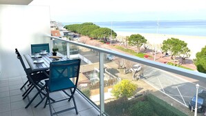 A balcony with a table and chairs, overlooking a beach and parking area. - Apartment Claire by Interhome (Arcachon)